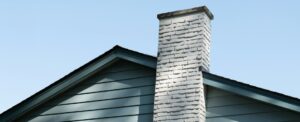 Homeowner examining roof layers and attic ventilation near shingles, flashing, and a roof vent.